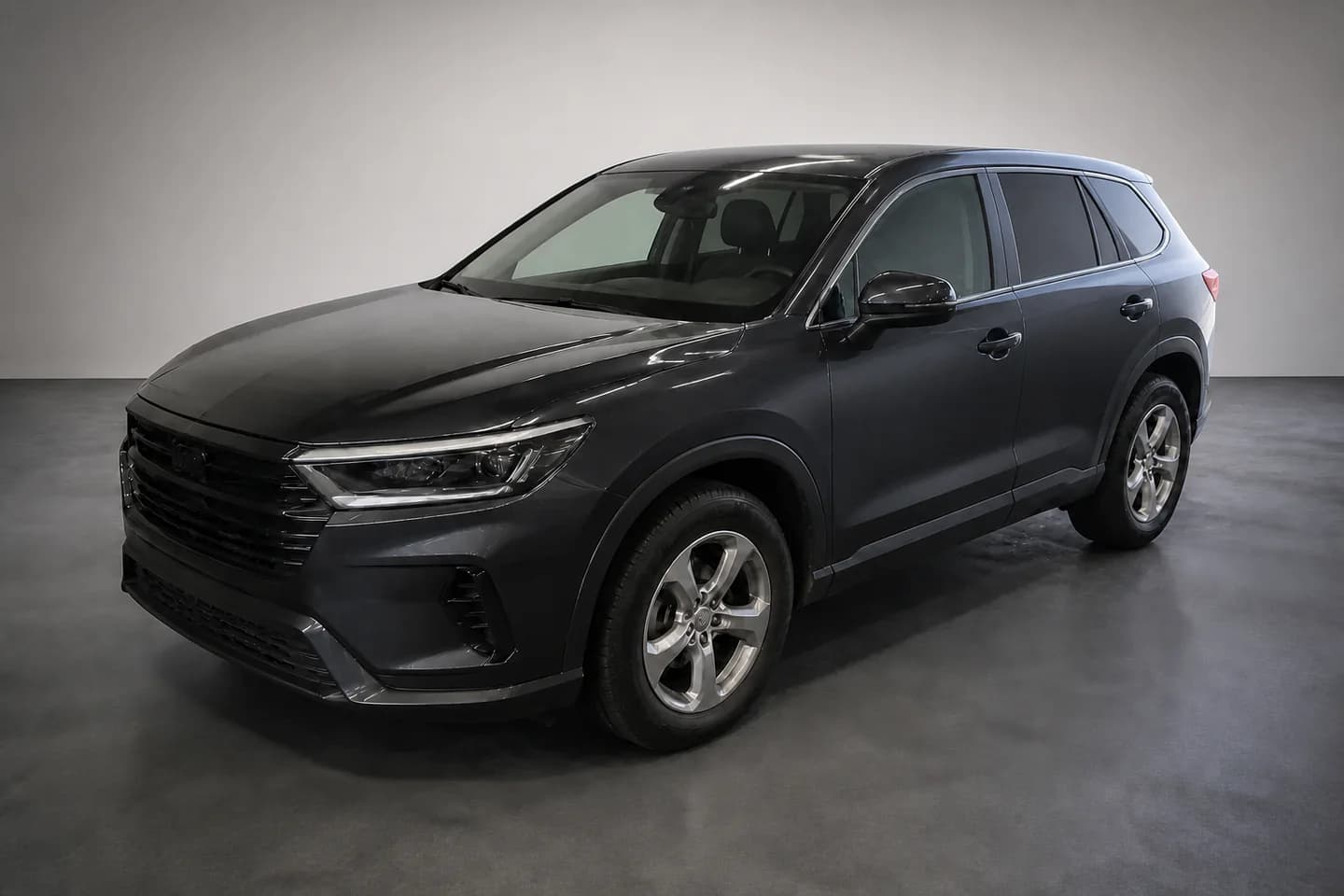 The same dark graphite crossover from the same angle in a clean neutral photo bay with balanced presentation lighting.